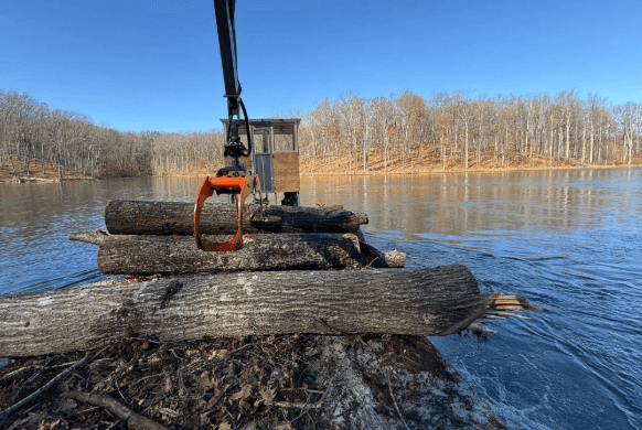 Hydraulic grapple loading timber from a barge platform
